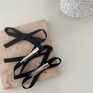 Detailed view of black fabric bow hair clips with silver metal anti-slip alligator teeth