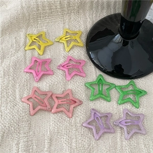 Detail of colorful glitter star hair clips with lemon yellow and lavender shades