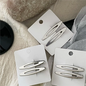 Nahaufnahme von drei Paar silbernen ovalen Haarspangen in minimalistischem Hohl-Design