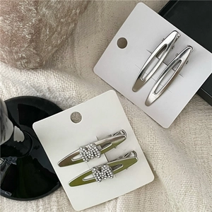 Detailansicht silberner Hohlblatt-Haarspangen und grüner M-Strass-Entenschnabelclips