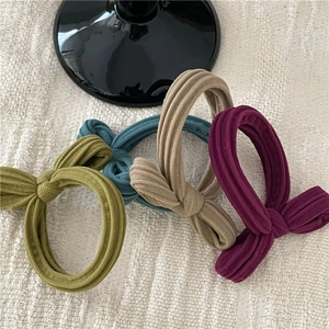 Detail of colorful bow hair ties in green, blue, khaki and purple corduroy texture