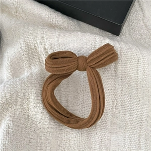 Detailed view of brown ribbed knit texture on a simple bow hair tie for daily use
