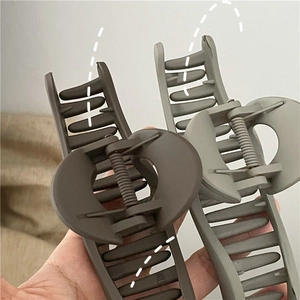 Detail of matte hair claws in coffee and sage green with strong metal spring