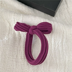 Detailed macro view of purple ribbed cotton bow hair tie on a decorative jewelry box