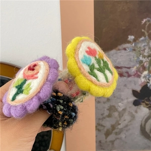 Nahaufnahme von Wollfilz-Blumen-Haargummis und bunten Frottee-Zopfgummis für Mädchen
