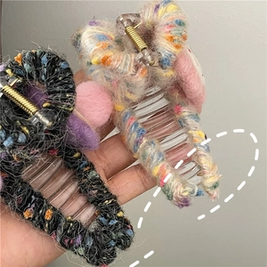 Detail showing colorful knitted wool texture on transparent hair claw clips