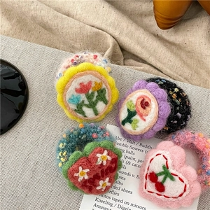 Handgemachte Haarspangen aus Wollfilz mit Blumen- und Herzmotiven und Stickerei