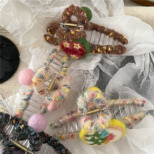 Detail of wool felt hair claw clips with handmade strawberry and daisy knit decorations