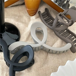 Close-up of matte Morandi geometric hair claws on beige fabric for hair styling