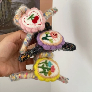 Three colorful knit hair claws with wool felt heart and floral embroidery patterns
