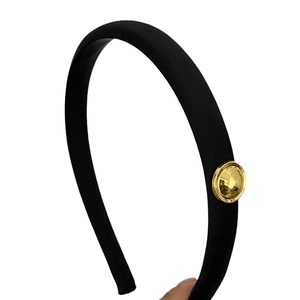 Elegant black satin texture thin headband featuring a decorative golden circular metallic piece