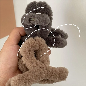 Detailed view of plush cross hair claws in dark gray and light brown faux fur