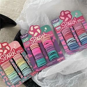 Close-up of colorful baby hair elastics on cards in macaron pink, purple and blue shades