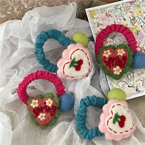 Handmade crochet heart hair ties with colorful pompons and cherry floral patterns