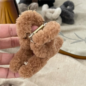 Detailed view of soft brown plush hair claw clip with golden spring mechanism