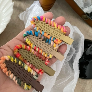 Primo piano di quattro fermagli per capelli in maglia colorata in giallo, marrone, verde e caffè