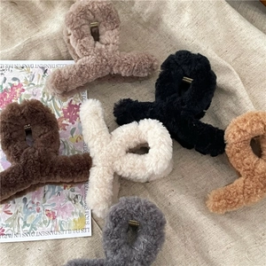 Flat lay of soft plush hair claws in coffee, beige, and grey for autumn styling