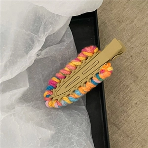 Dettaglio dell'intreccio in filato colorato su un fermaglio a goccia color kaki