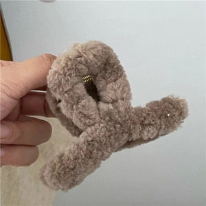 Close-up of soft brown plush hair claw clip showing fluffy texture and spring mechanism