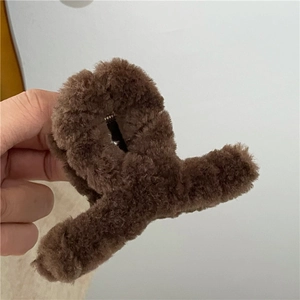 Detail of soft dark brown plush hair claw clip showing furry texture and metal spring