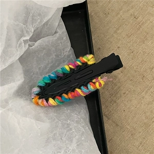 Dettaglio della trama in filato arcobaleno su una clip per capelli a goccia nera