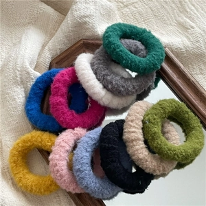 Close-up of colorful plush scrunchies showing soft faux fur textures on a tray