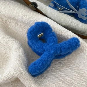 Close-up of fluffy Klein blue plush hair claw clip showing soft texture and metal spring