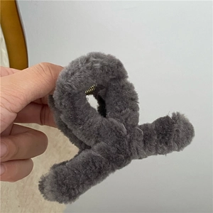 Close-up of deep grey plush hair claw clip with soft faux fur and metal spring detail