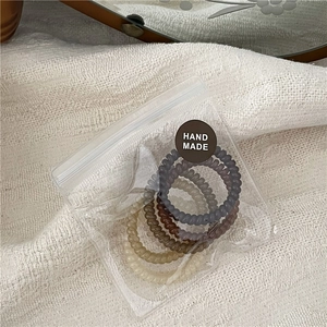 Set of four jelly spiral hair ties in coffee tones inside a handmade gift bag