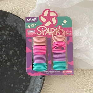 Detail of colorful elastic baby hair ties on a display card for fine ponytails