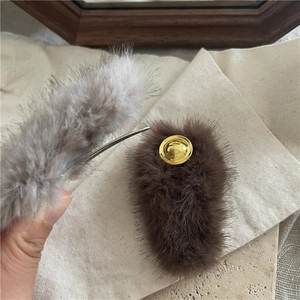 Detailed view of plush faux mink fur hair clips in dark brown and light grey colors