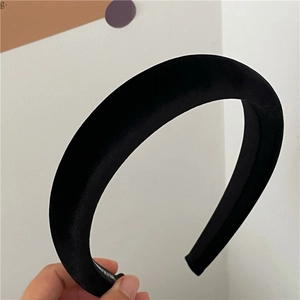Close-up of a thick black velvet padded headband for a minimalist high-top hairstyle