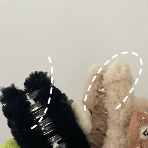 Vue détaillée des pinces à cheveux en peluche noir et beige avec décor d'ours mignon