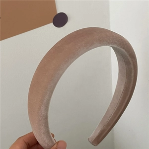 Detail shot of a thick velvet headband in light coffee with a soft plush texture