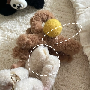 Détail de pinces à cheveux en polaire pelucheuse avec texture laine et dents en plastique