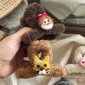 Gros plan sur des pinces à cheveux en peluche avec des figurines de poupée et chat