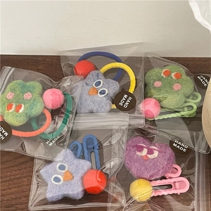 Detail of handmade wool felt star and heart hair clips in individual packaging