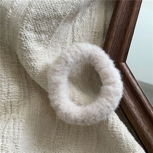 Detailed close-up of soft cream plush hair scrunchie with fluffy mink-like texture