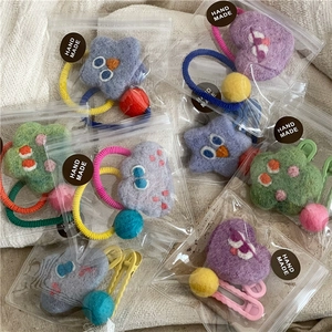 Detail of handmade star and heart wool felt hair clips and ties in gift packaging