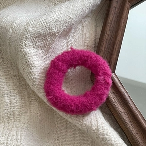 Close-up of fluffy bright pink plush hair scrunchie with soft faux fur texture