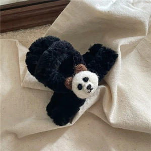 Détail d'une pince à cheveux en peluche noire avec un petit panda mignon en feutre