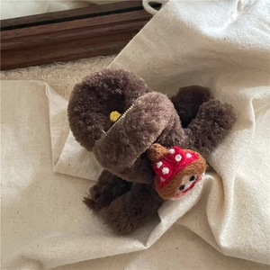 Gros plan détaillé d'une pince à cheveux en peluche marron avec un petit champignon en feutre