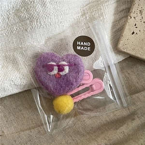 Close-up of purple heart wool felt hair clip with cute embroidery and yellow ball detail