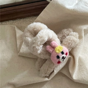 Détail de la pince à cheveux en laine d'agneau avec lapin crocheté rose et fleur jaune
