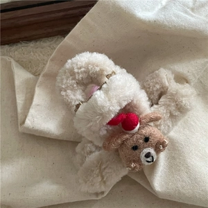 Vue détaillée d'une pince à cheveux en peluche avec un petit ours et bonnet de Noël