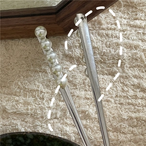 Détails d'épingles à cheveux en argent avec perles blanches sur fond en tricot doux