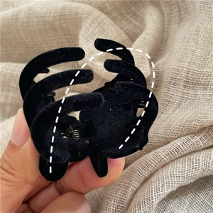 Dettaglio della piccola molletta per capelli in velluto nero con morbida texture floccata