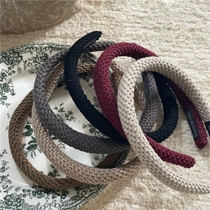 Detailed close-up of handmade chunky knit headbands in various solid autumn colors