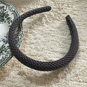 Detail of dark grey knitted headband showing chunky texture and handmade label