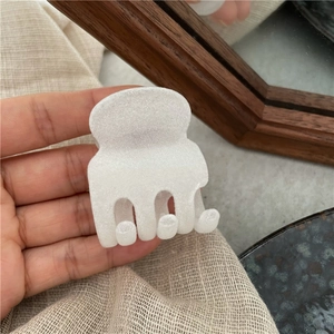 Dettaglio di una mini clip per capelli floccata bianca con morbida finitura opaca